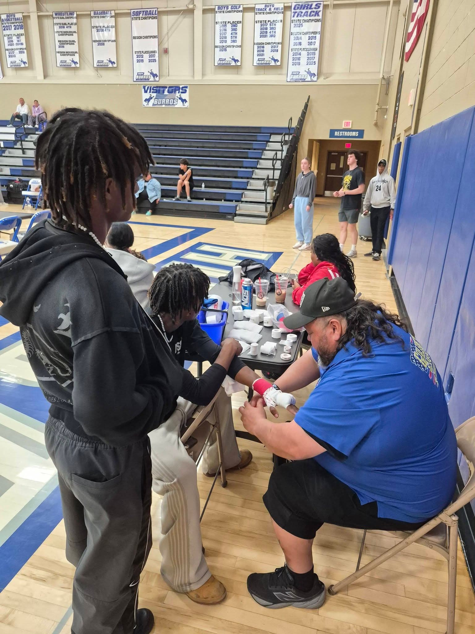 A coach wrapping a fighter's hands before a bout