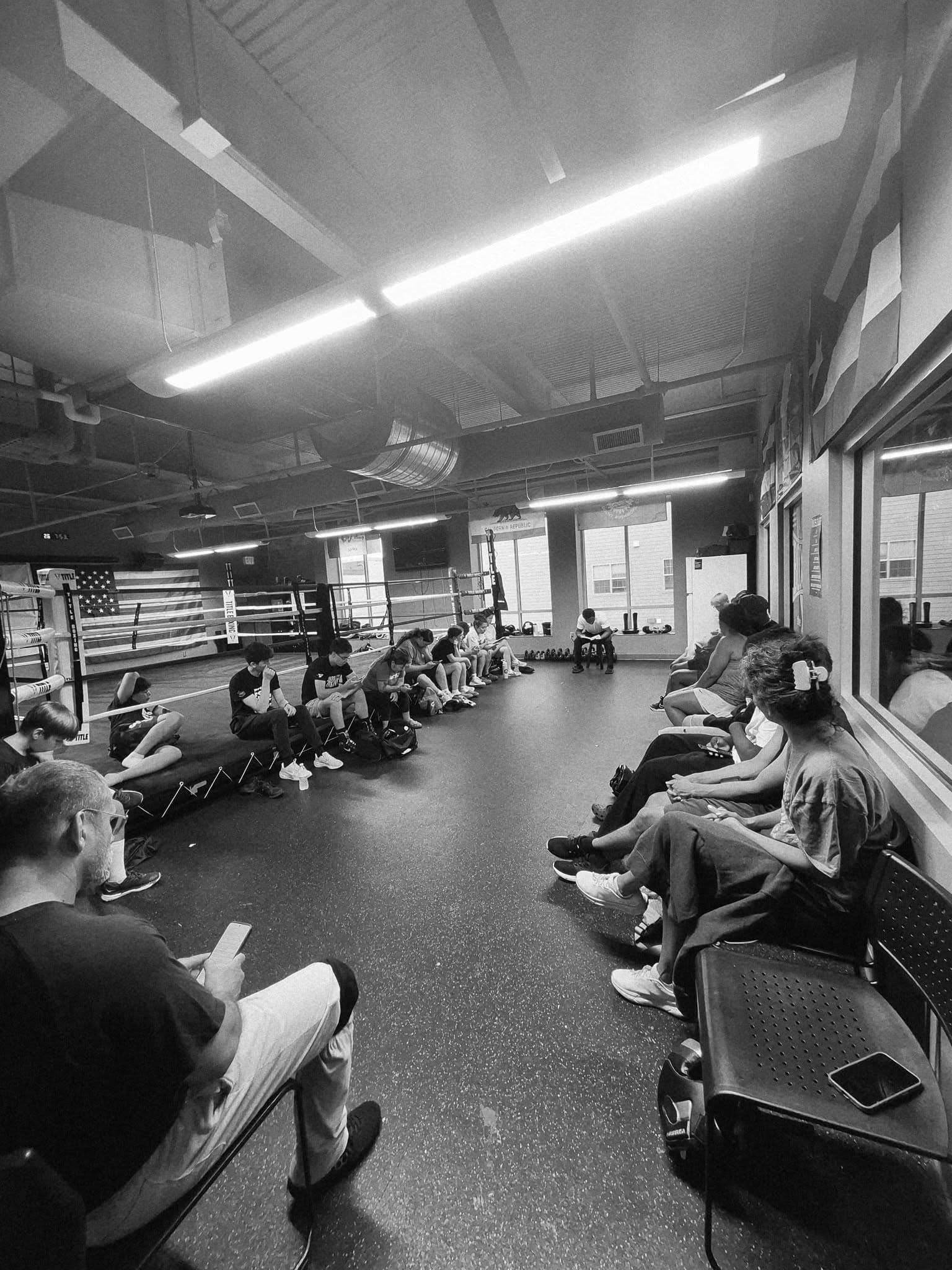 Fighters resting along the wall between rounds