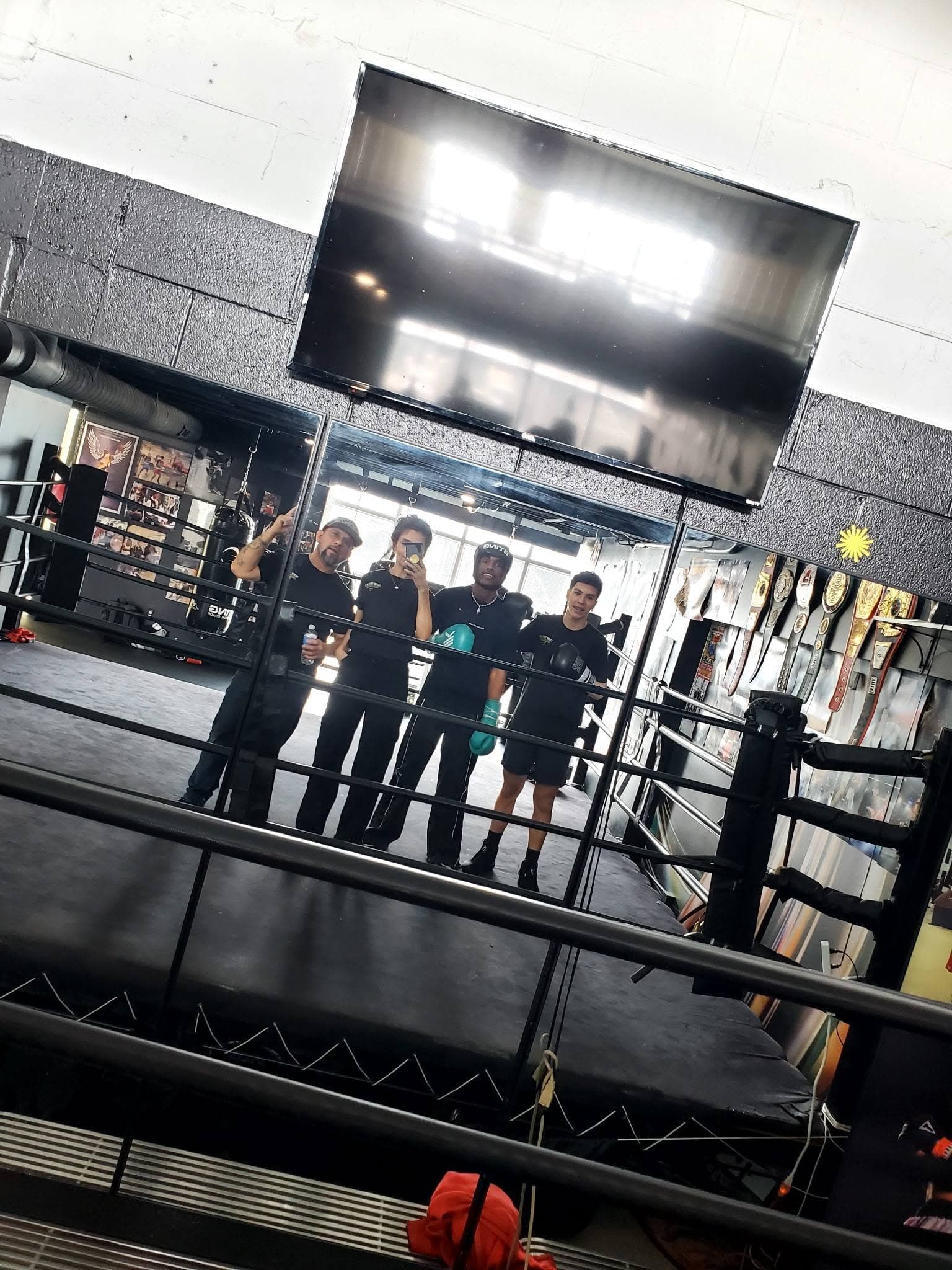 The team gathered by the ring at the gym